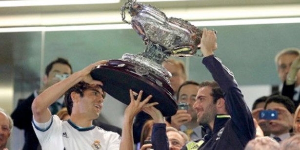 Kaká (izq) ayuda a levantar la Copa Santiago Bernabéu.
